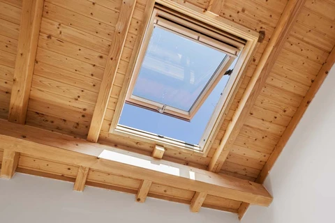 Intérieur d'une maison avec charpente en bois apparente sous combles