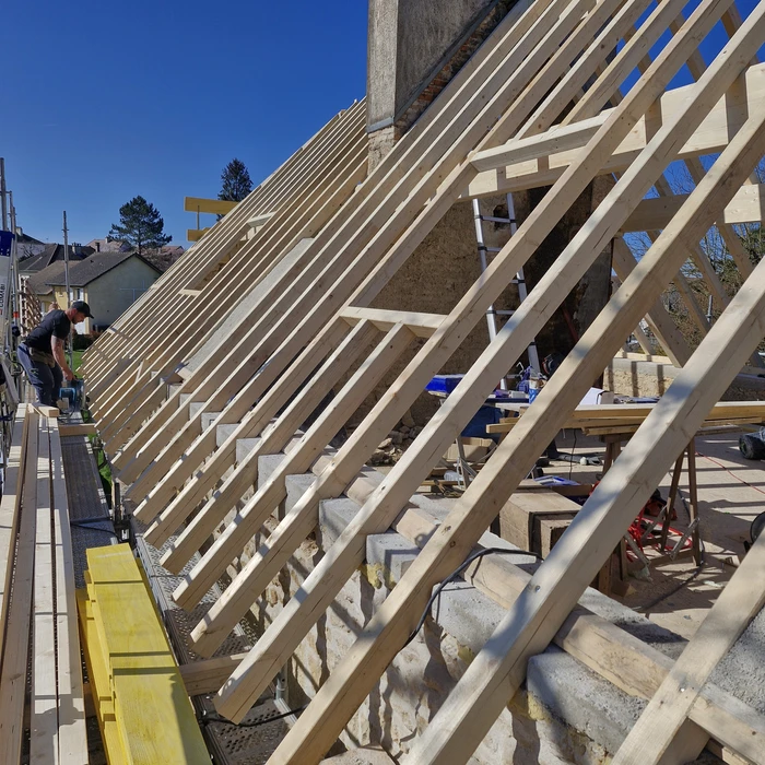 Construction d'une maison écologique en ossature bois avec isolation paille sur chantier extérieur