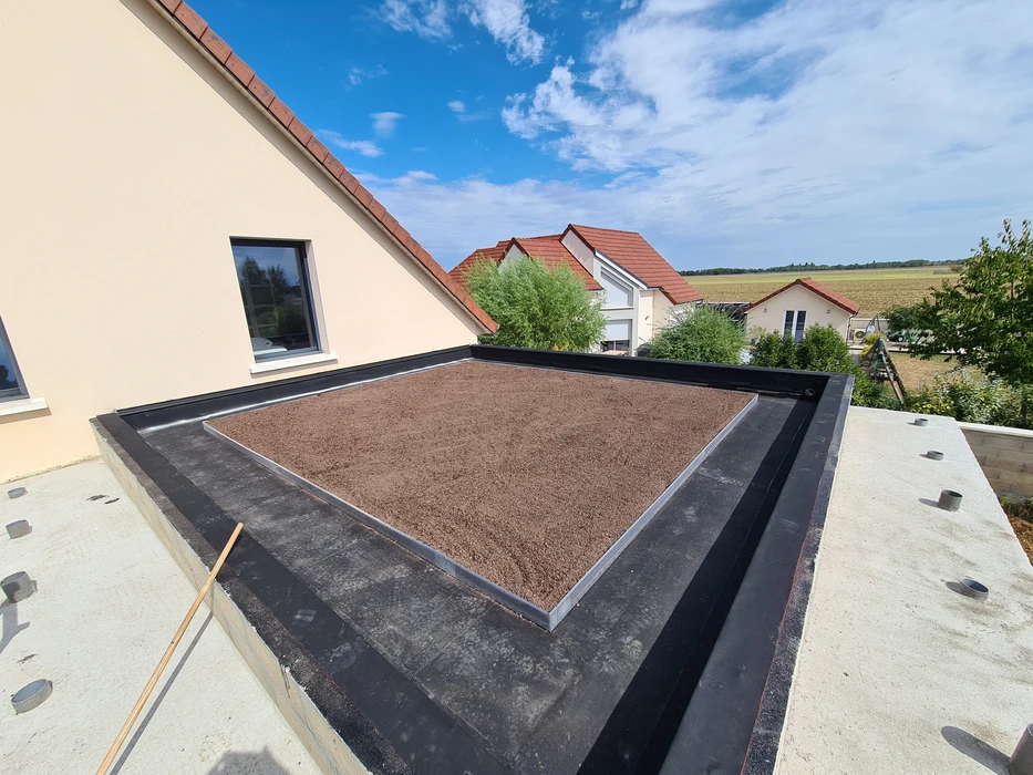 Maison moderne en construction avec bardage bois naturel et toiture ardoise grise