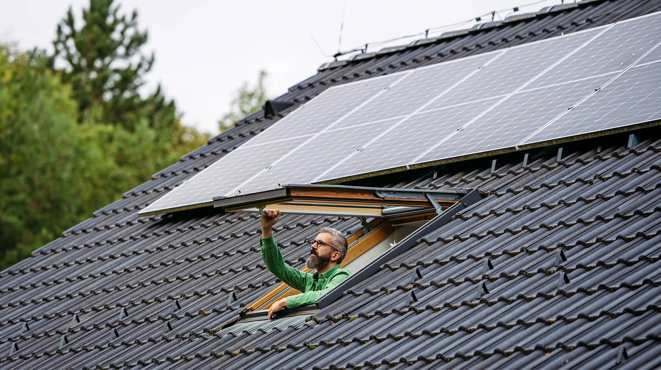 Fenêtre sur le toit en gros plan et cadre de fenêtre en bois sur fond de ciel flou