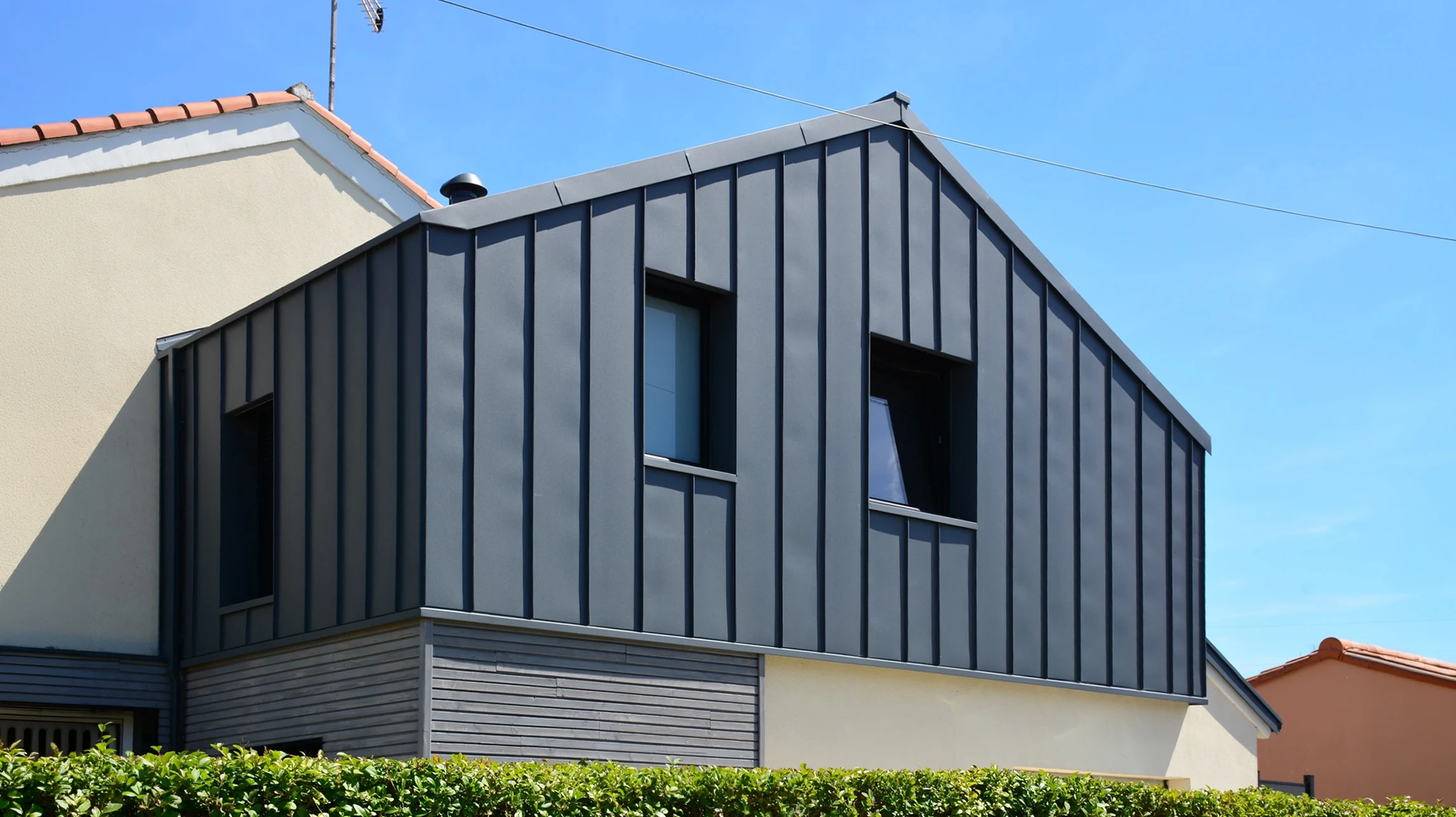 Maison contemporaine à ossature bois avec bardage en bois naturel et toiture ardoise
