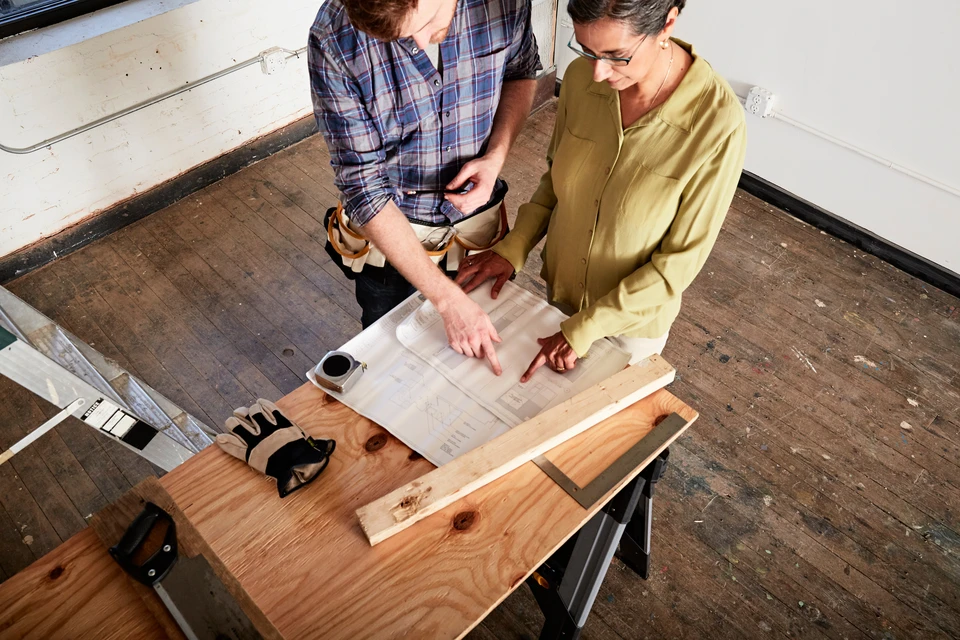 Ouvrier couvreur installant des tuiles terre cuite sur charpente bois, travaux de toiture en cours
