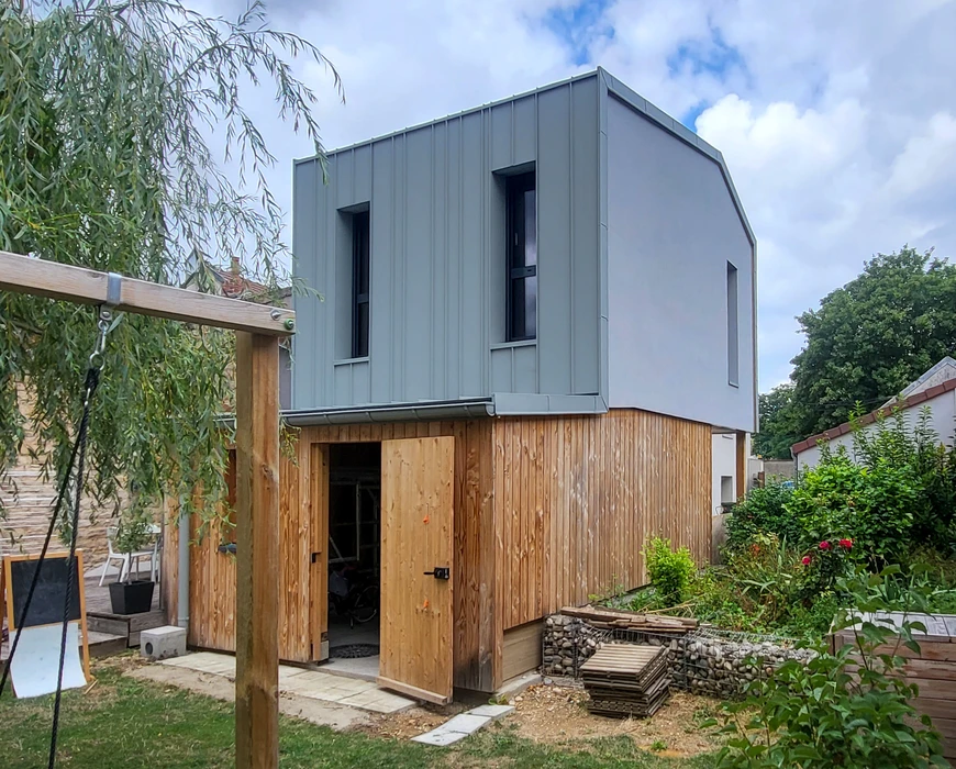 Maison contemporaine à ossature bois avec bardage en lames horizontales, située dans un environnement paysager verdoyant