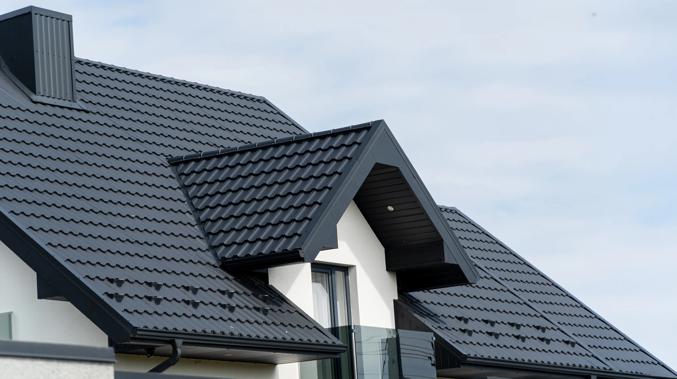 Ouvrier couvreur installant des tuiles terre cuite sur charpente bois, travaux de toiture en cours